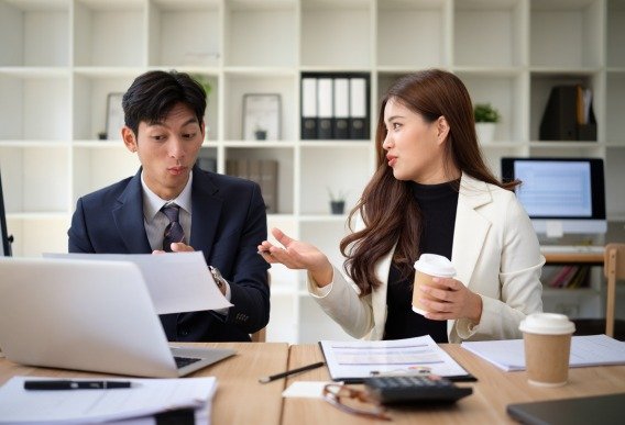 Business professionals discussing a project at a desk, illustrating custom and scalable WordPress development solutions